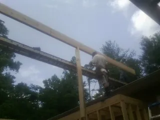 Carpenter setting a ridge beam over a new addition frame — Ice Dam Removal by Roofing Brothers in Toddville