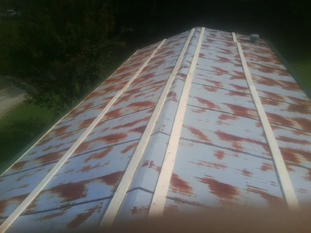 Rusted metal roof panels with new wood purlins before replacement — Storm Damage Roof Repair in Toddville by Roofing Brothers