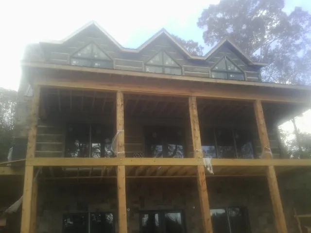Dormers and porch framing on a large log home under construction in Toddville